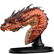 THE HOBBIT - Smaug the Terrible - Bust Edition Statue (Weta Workshop). A highly detailed fantasy dragon bust sculpture on a black display stand, featuring textured orange and red scales with dark spines and a beige underbelly, set against a plain white background.