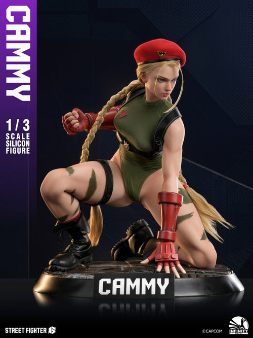 Street Fighter Cammy 1/3 scale collectible statue on a dark display base, shown in a crouching pose with a red beret, olive green outfit, and red arm guards against a dark blue background.