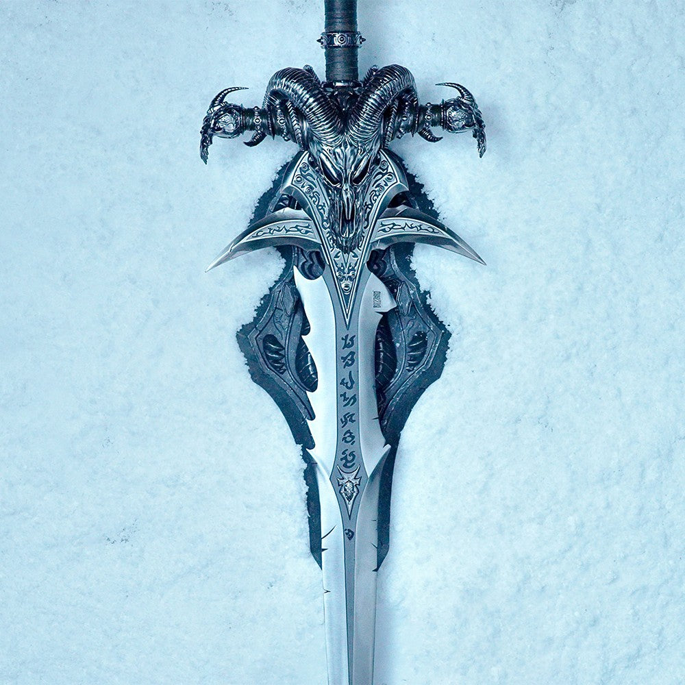Frostmourne Sword Replica Scale 1/1 - World of Warcraft Cursed Sword of the Lich King. A fantasy-style sword with an ornate ram skull hilt and detailed silver blade, photographed upright against a pale icy blue textured background.