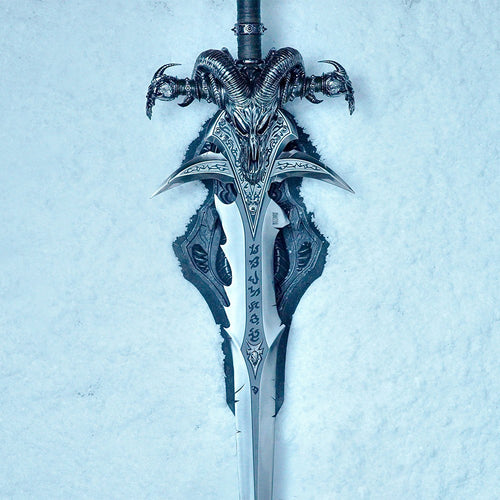 Frostmourne Sword Replica Scale 1/1 - World of Warcraft Cursed Sword of the Lich King. A fantasy-style sword with an ornate ram skull hilt and detailed silver blade, photographed upright against a pale icy blue textured background.