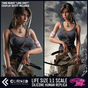 Lara (Tomb Raider) Realistic Silicone 1:1 Replica Cosplay Model Doll (Game Lady). Promotional product image for a life-size 1:1 scale silicone human replica of Lara Croft from Tomb Raider, shown in two side-by-side views. The left view shows the character against a dark gray background with text stating 'Tomb Raider "Lara Croft" Cosplay Outfit Included,' and the right view shows her in a rainier outdoor scene. Lara Croft Sex Doll.